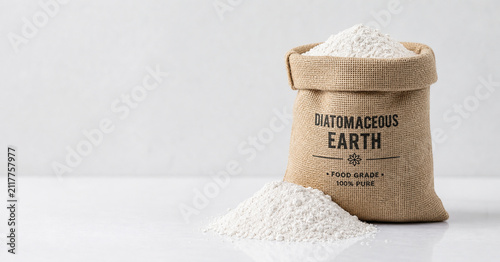 Burlap sack of diatomaceous earth with spilled powder on sweep, ecommerce banner concept