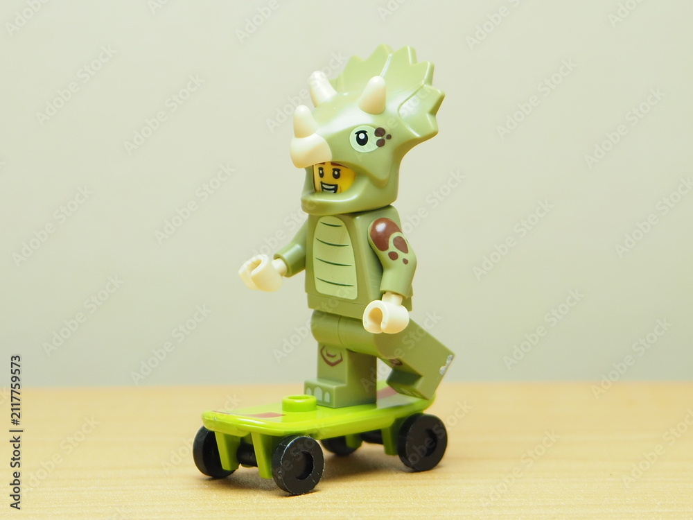 Fototapeta premium Indonesia - February 10, 2026 : Mini toy of action figure at outdoor with blur background. Miniature photography concept design. Minifigure of Triceratops character playing skate board at sport arena.