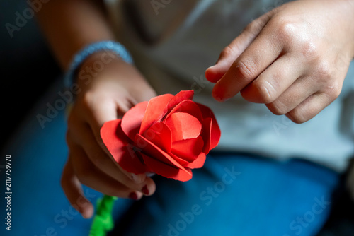 Fotografie Child holding handmade paper rose after creative DIY craft project