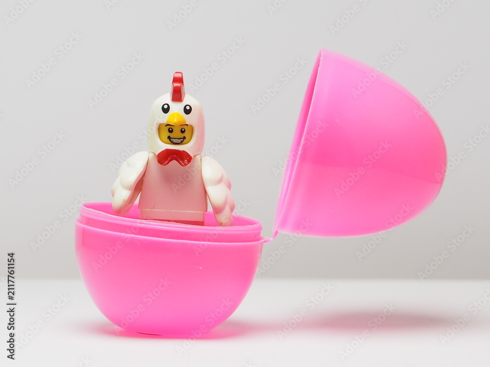 Fototapeta premium Indonesia - February 8, 2026 : Mini toy of action figure at outdoor with blur background. Miniature photography concept design. Minifigure of baby chicken character coming out from egg. New born bird