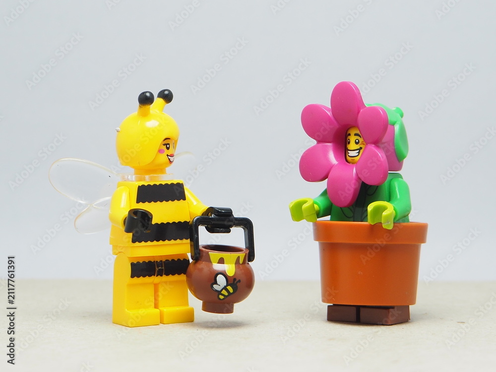 Fototapeta premium Indonesia - January 5, 2026 : Mini toy of action figure at table with blurred background. Miniature photography concept design. Minifigure of Flower and Yellow Bee character at garden.