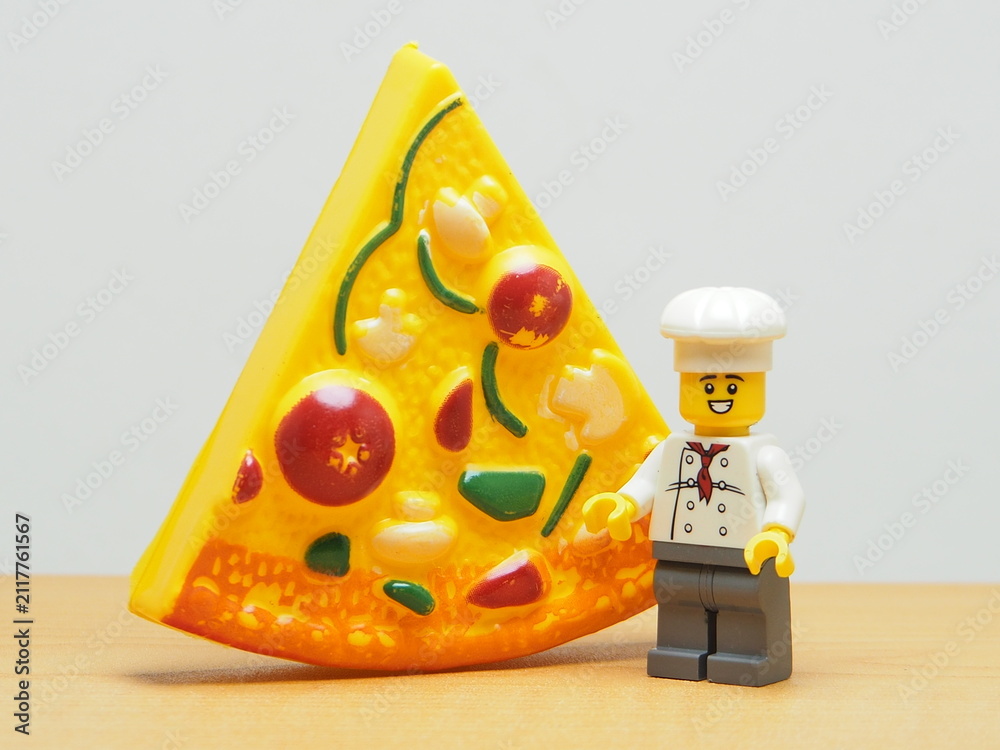 Fototapeta premium Indonesia - January 4, 2026 : Mini toy of action figure at outdoor with blurred background. Miniature photography concept design. Minifigure of Young Chef character with Pizza, Pan and food truck.