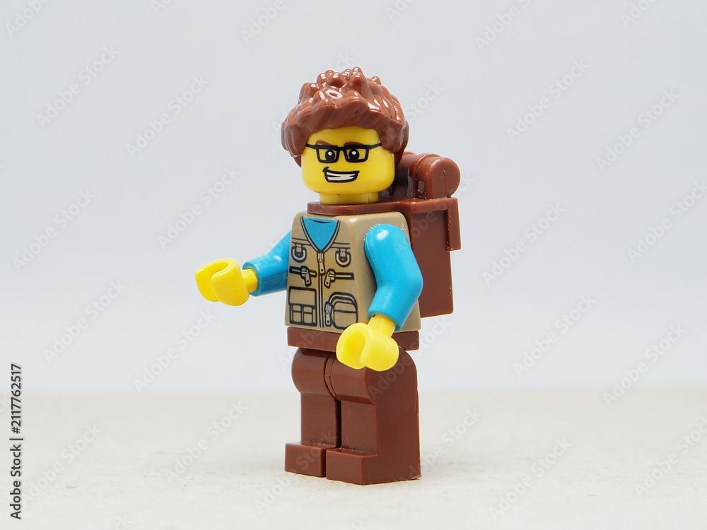 Fototapeta premium Indonesia - November 30, 2025 : Mini toy of action figure at outdoor with blur background. Miniature photography concept design. Minifigure of traveler character with binocular and backpack at nature.