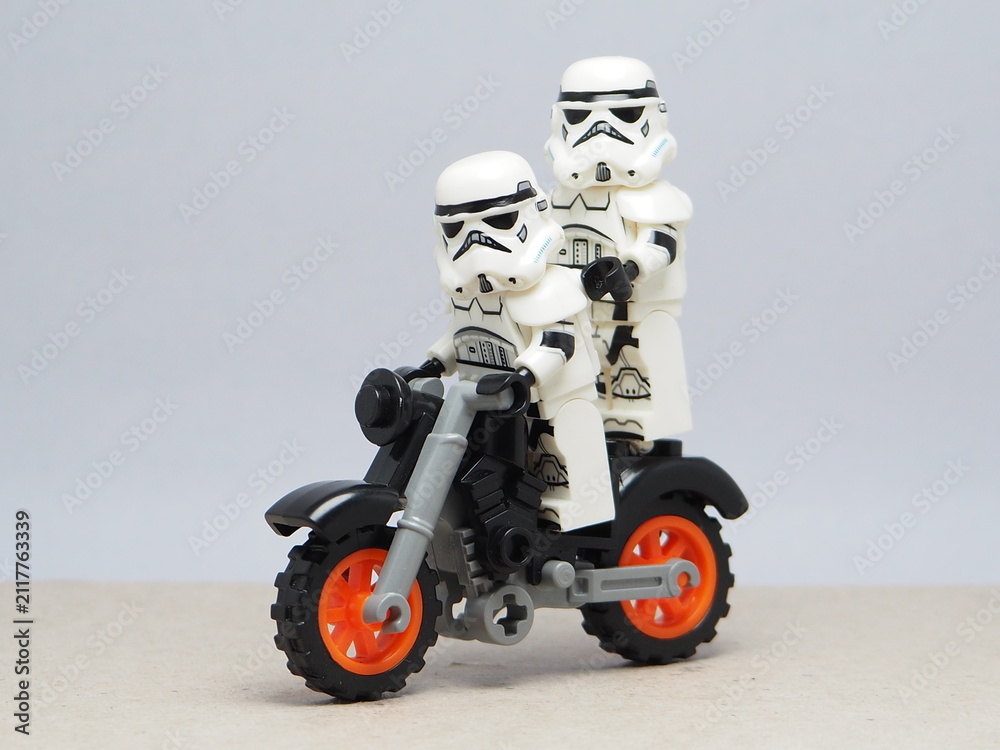 Obraz premium Indonesia - December 5, 2025 : Mini toy of action figure at outdoor with blurred background. Miniature photography concept design. Couple of stormtrooper minifigure character riding motorcyle together