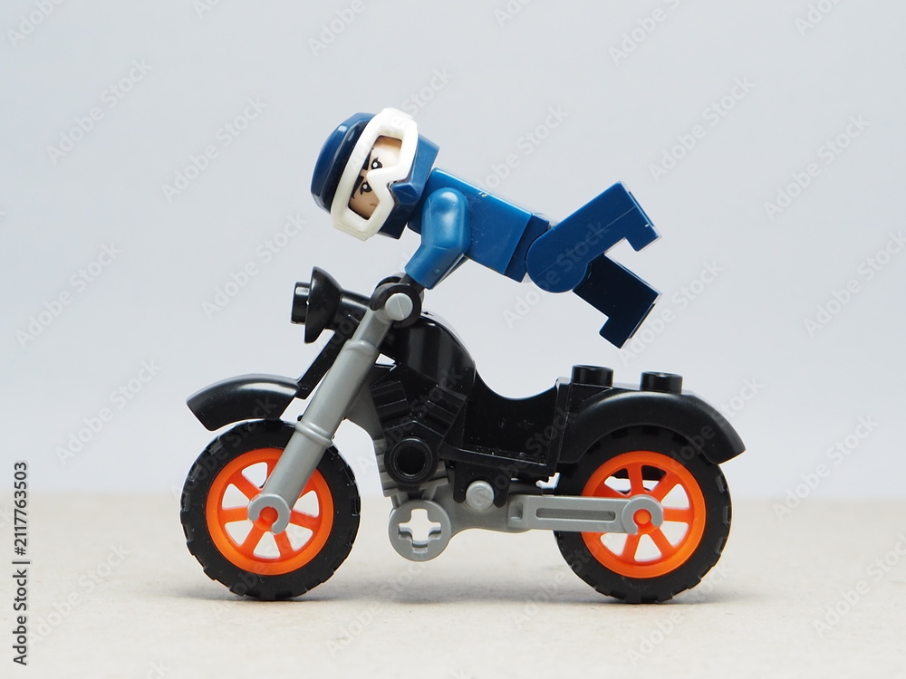 Fototapeta premium Indonesia - December 5, 2025 : Mini toy of action figure at outdoor with blurred background. Miniature photography concept design. Minifigure of freestyler athlete character jumping with motorcycle.