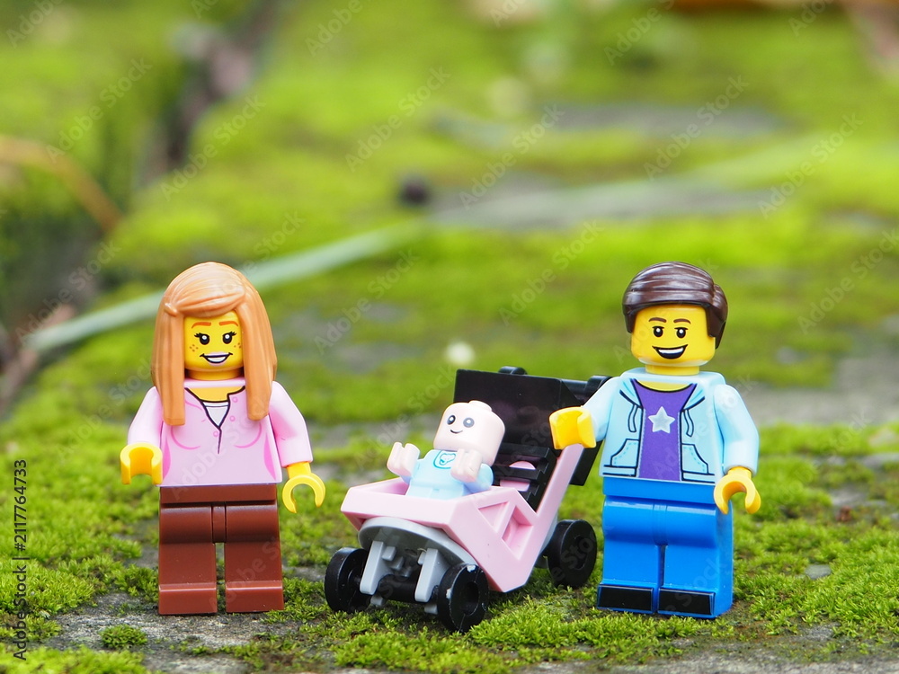 Fototapeta premium Indonesia - November 23, 2025 : Mini toy of action figure at table with blurred background. Miniature diorama photography concept design. Minifigure of Mother, Father and baby character with stroller.