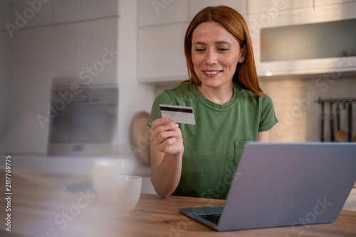Woman holding credit card doing online shopping on laptop