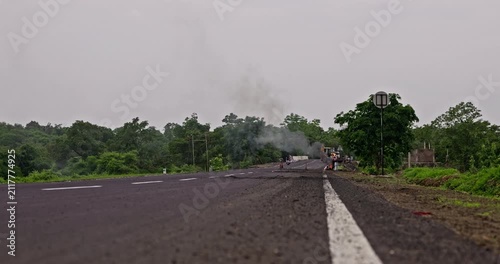 Workers Heating Hot Bitumen in a Metal Drum for Rural Road Construction and Maintenance, vertical and horizontal video