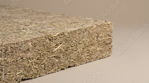 Sustainable hemp insulation block featuring a rough organic texture for eco friendly construction projects isolated on a neutral beige background