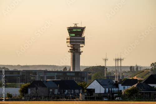 Cuadro en lienzo The air traffic control tower of Brussels Airport rises above the treeline in Belgium at golden hour, a key piece of aviation infrastructure against the evening sky