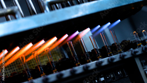 ampoule making using fire in injection pharmaceutical factory. glass tubes for vaccine manufacturing factory. ampoule manufacturing line. pharmaceutical vaccines. ampoules making