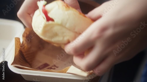 Opening Takeout Box and Taking Out Fresh Homemade Burger. Close-up of hands opening a biodegradable takeout box to reveal a fresh homemade burger, then lifting it out.