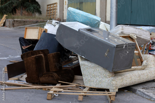 фотографія Bulky waste and old furniture illegally dumped on a city street pavement