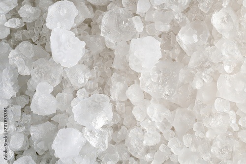 Close-up image of irregularly shaped, semi-transparent white stones or crystals with intricate textures and patterns. micro photography
