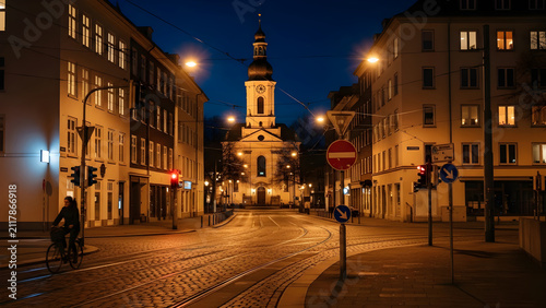 A tranquil evening scene in a historic European city street with a cyclist passing a glowing church under the night sky