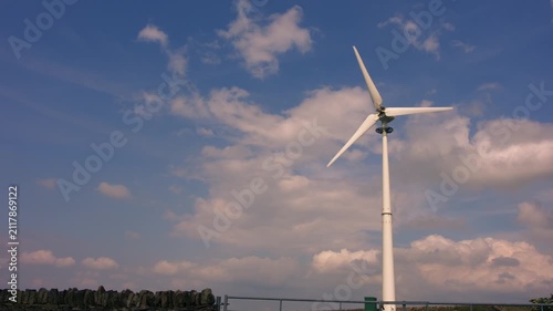Solitary wind turbine against blue cloud sky