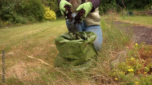 Gardener putting soil compost in green grow bag