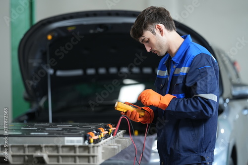 Obraz na płótnie EV Technician Performing High Voltage Battery Diagnostics with Digital Multimete