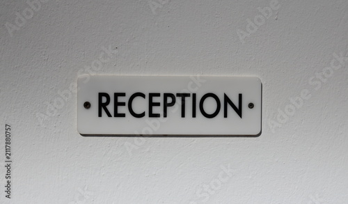 Sign of reception on the white wall of a hotel, information for tourists