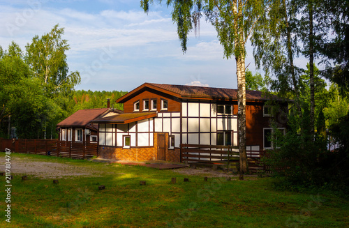 A wooden rural house in the forest. Nice cottage with beautiful garden in a countryside.