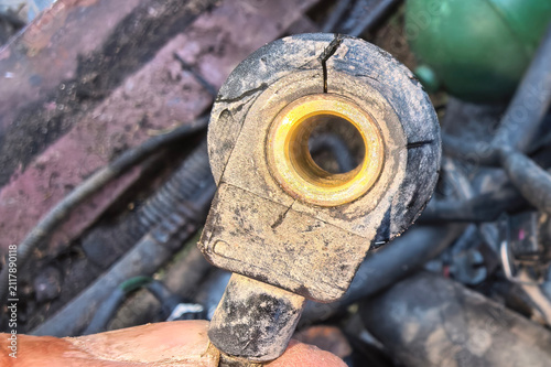 Close view of a damaged car part showing cracks and dirt from a repair setting