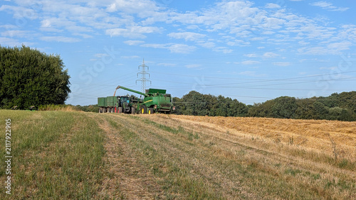Canvastavla Combine harvester unloading grain into a tractor trailer.