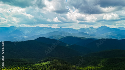 Fotografía Hazy mountain tiers stretch to the horizon with alternating bands of light and shadow