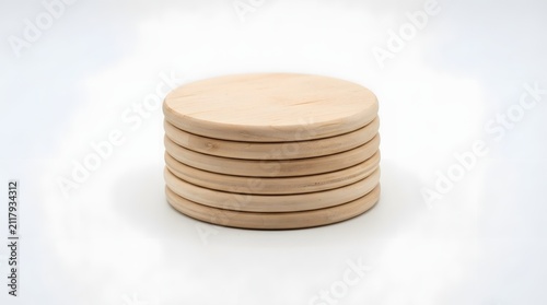A stack of round wooden coasters isolated on a clean white background for home decor and kitchen use