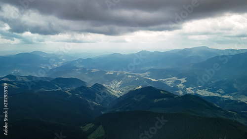 Cuadro en lienzo Moody weather blankets a sea of mountains where blue ridges recede into haze and