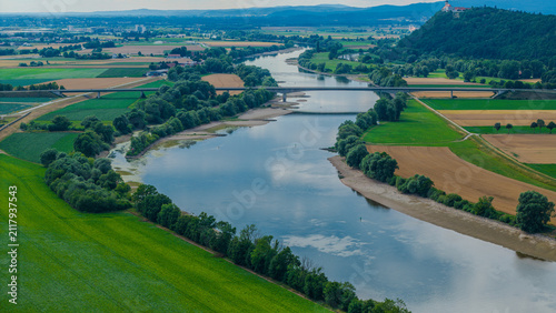 Blick auf einen Fluss umgeben von Feldern und Bäumen in einer ländlichen Umgebung