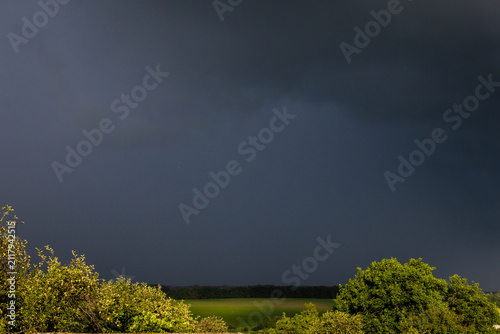 Принти на полотні A dense curtain of rain and cloud approaches across open farmland the land still