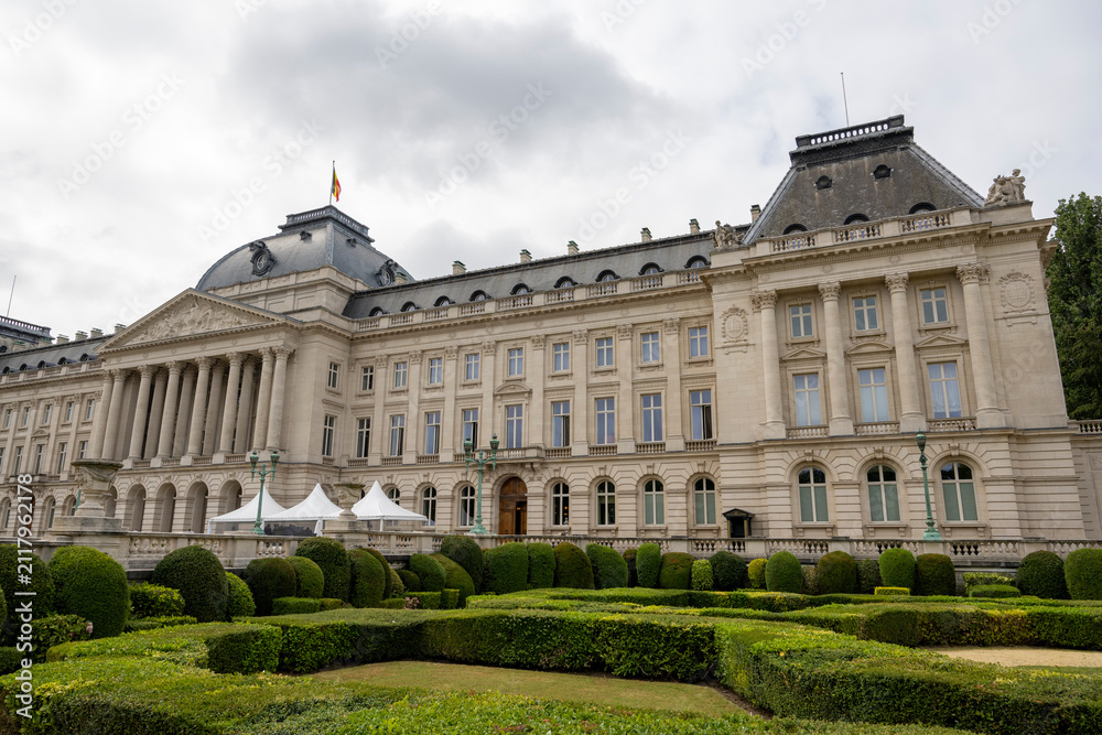 Fototapeta premium Royal Palace of Brussels with formal gardens and elegant neoclassical façade under a dramatic cloudy sky, showcasing one of Belgium's most iconic architectural landmarks in the city center