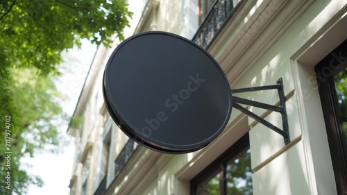 Round black outdoor shop sign mockup hanging from a metal bracket