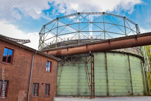 Old, rusty, abandoned factory with a storage tank