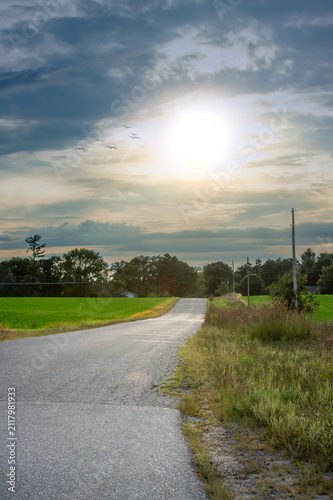 Country Road Lead Away in Distance Under Setting Sun