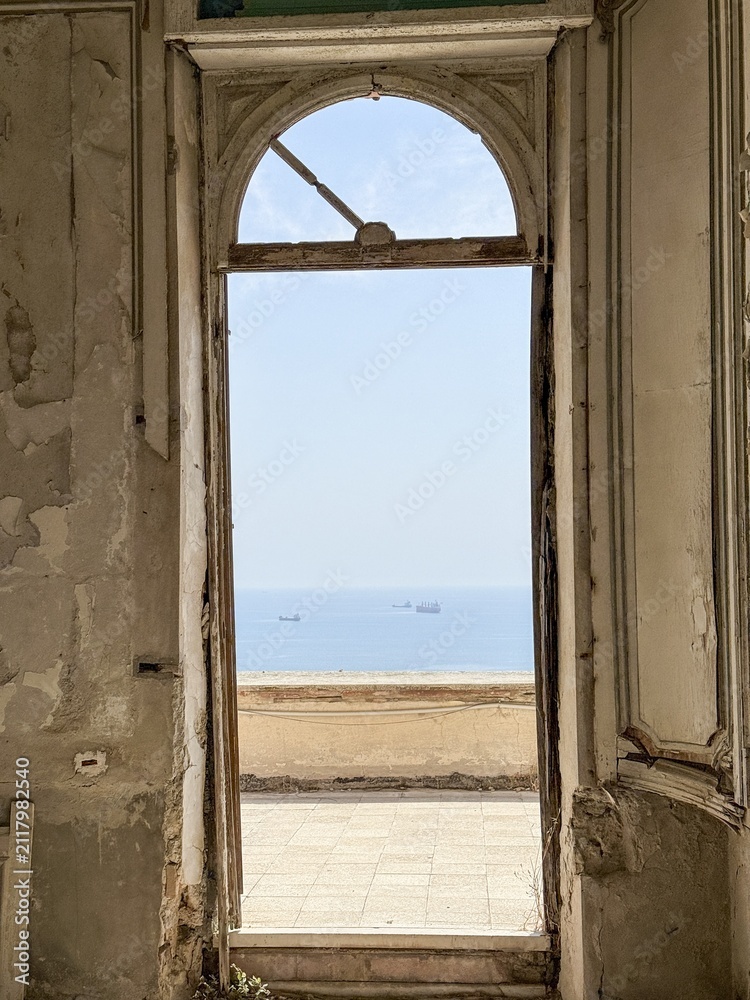 Obraz premium Historic doorway framing peaceful sea view through ancient architecture