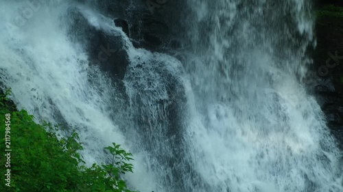 Waterfall running down rocks surrounded by trees in a forest during daylight hours