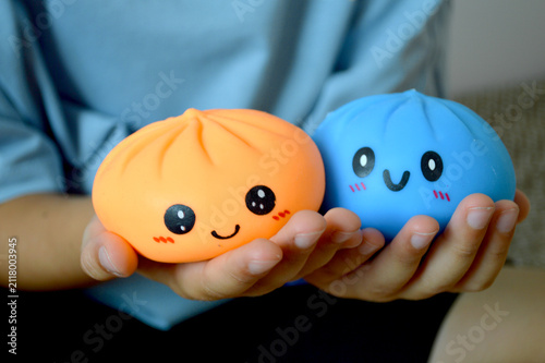 Foto Hands gently holding two cute kawaii squishy dumpling character toys with happy