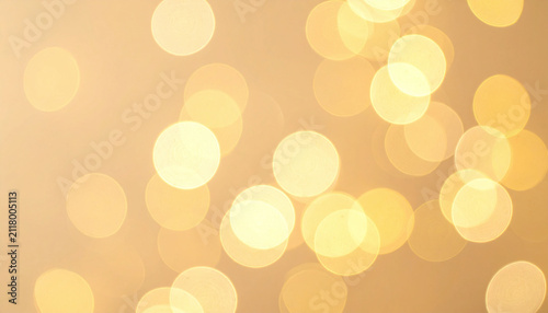 A dreamy golden bokeh background with warm, shimmering light orbs creates an elegant, festive atmosphere. Nobody is present in this abstract, artistic texture perfect for luxury branding projects.