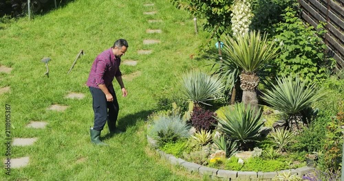 Gardener landscaping a Mediterranean style arrangement with Yuccas and cactuses
