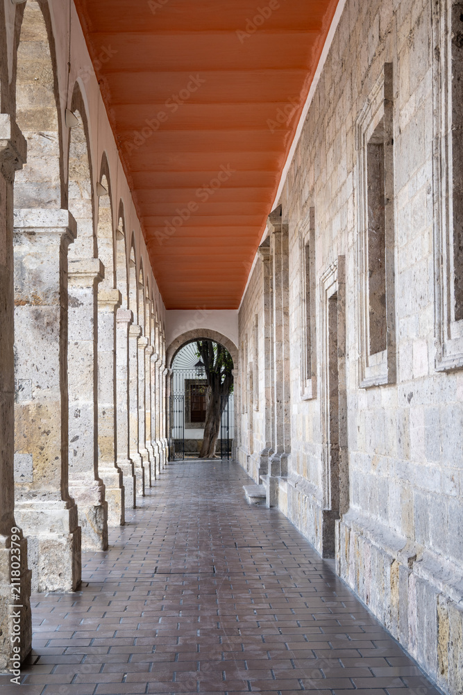 Fototapeta premium Captivating long stone archway corridor within the historic Cabanas Cultural Center in Guadalajara. Detailed old architecture.