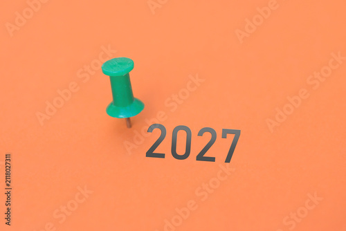 Eine Heftzwecke und ein Blatt Papier mit der Jahreszahl 2027 