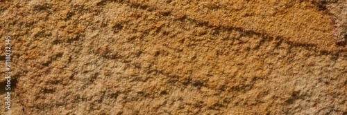 фотографія Sandstone surface showing natural rough texture and earth tone colors