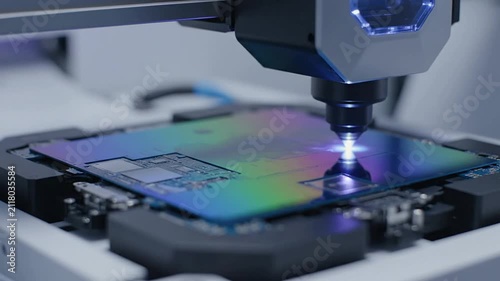 Close-Up View of Advanced Semiconductor Manufacturing Equipment Inspecting Shiny Silicon Wafer Under Bright Illumination in Clean Room Environment