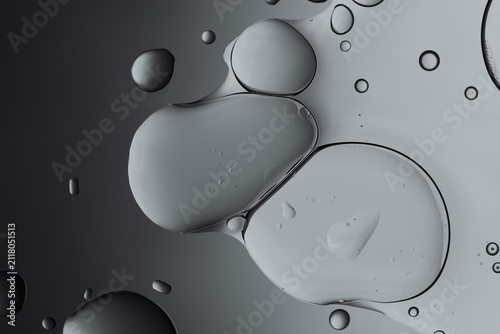 Oil and water grey bubbles merging abstract background