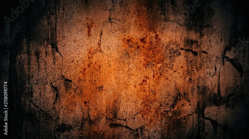 A textured wall showing a mix of dark shadows and intense orange rust patterns throughout