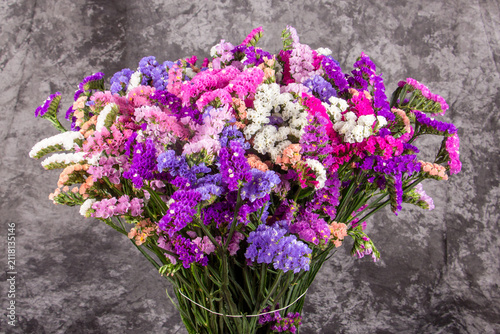 Фотография Collection of fresh statice flower bouquets in vibrant shades of purple, pink, lavender, peach, and white photographed during a professional floral production session