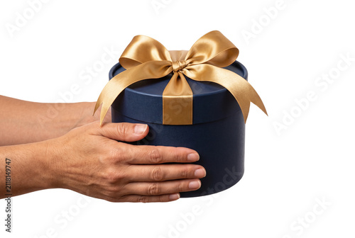 Hands holding round navy gift box with golden bow
