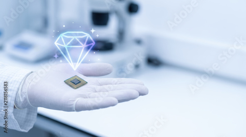 Semiconductor chip in gloved hand for supply squeeze in clean lab with diamond icon and soft focus