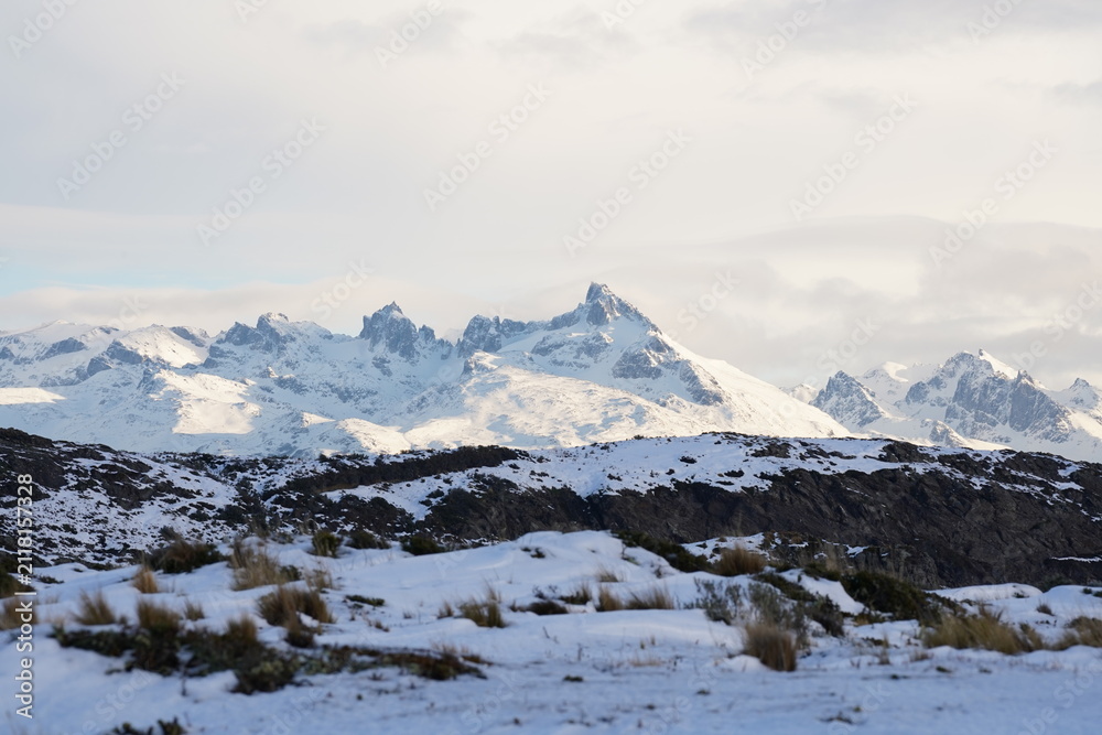 Fototapeta premium Snow covered jagged mountain peaks under winter sky in Ushuaia Patagonia Argentina